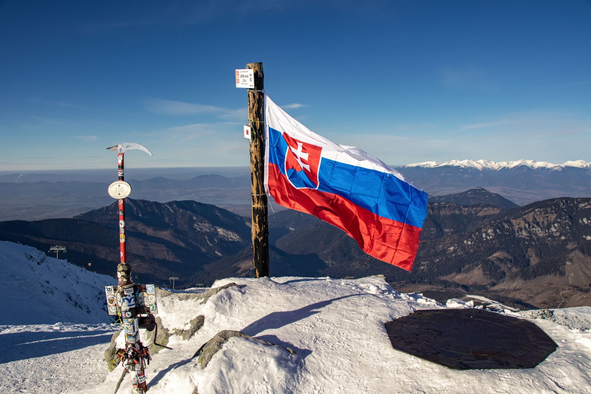 Flaga Słowacji na ośnieżonym szczycie z panoramą gór