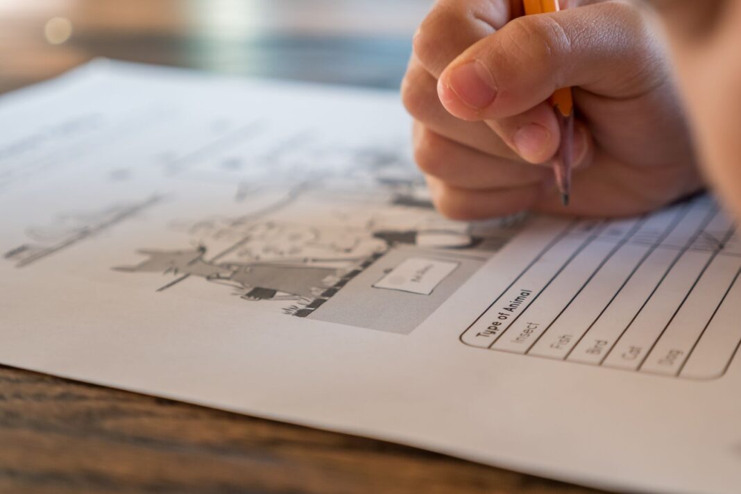 Uczeń szkoły podstawowej wypełnia test o zwierzętach ołówkiem Uczeń szkoły podstawowej wypełnia test o zwierzętach ołówkiem